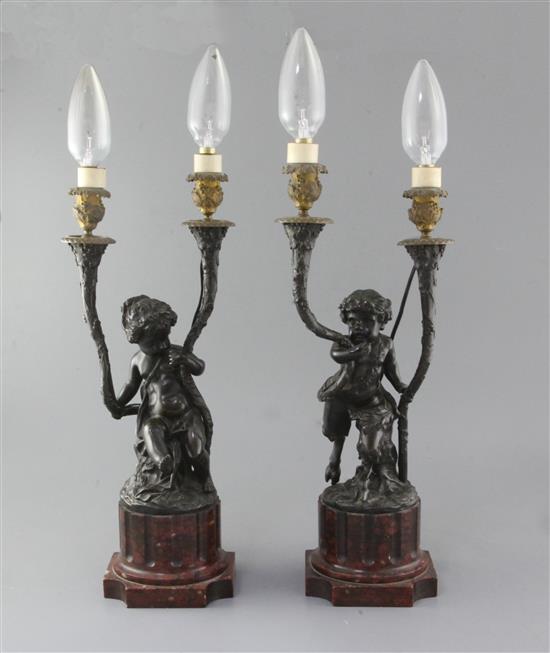 After Clodion. A pair of 19th century French bronze and ormolu candelabra, 18in., later fitted for electricity